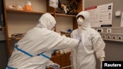 Arhiva - Medicinski radnici oblače zaštitnu opremu u odeljenju intenzivne nege u Kliničkom centru Vojvodine, tokom pandemije koronavirusa, u Novom Sadu, 2. aprila 2020.