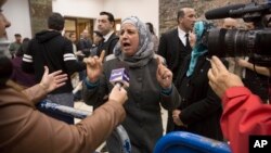 Suha Abu Khdeir, center, mother of Mohammed Abu Khdeir, a 16-year-old Palestinian murdered in 2014, speaks to reporters at a court during the sentencing of two Israelis accused of his murder, in Jerusalem, Feb. 4, 2016. 