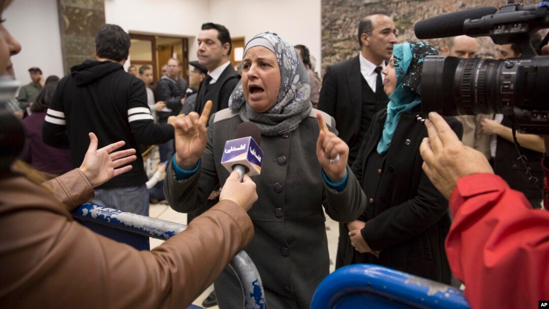 Suha Abu Khdeir, center, mother of Mohammed Abu Khdeir, a 16-year-old Palestinian murdered in 2014, speaks to reporters at a court during the sentencing of two Israelis accused of his murder, in Jerusalem, Feb. 4, 2016. 