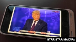 FILE - President Donald Trump appears on a cell phone during a town hall in Pennsylvania, Sept. 15, 2020. 