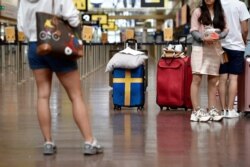 Passengers prepare to check in at Arlanda airport for the first chartered TUI flight to Rhodes in Greece since the outbreak of the coronavirus disease (COVID-19), in Stockholm.