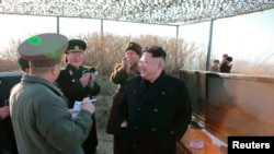 FILE- North Korean leader Kim Jong Un and officials gather to observe the test firing of a new type of anti-ship cruise missile in this undated photo released by North Korea's Korean Central News Agency in Pyongyang, Feb. 7, 2015.