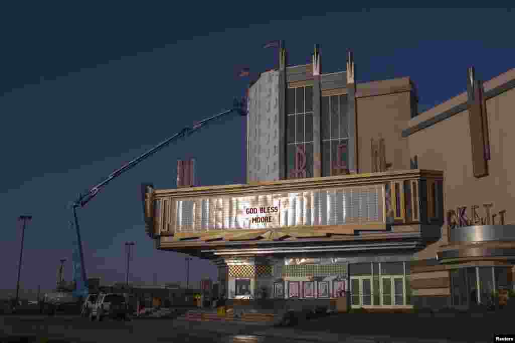 A sign reads &quot;God Bless Moore&quot; as workers make repairs to the Warren theater in Moore, Oklahoma, which was left devastated by a tornado, May 22, 2013. 