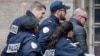 Former Kosovo prime minister Ramush Haradinaj, right, is rushed by police officers inside the Colmar courthouse in France, Jan.5, 2017. Haradinaj is facing possible extradition to Serbia to face war crimes charges after being arrested at a French airport.