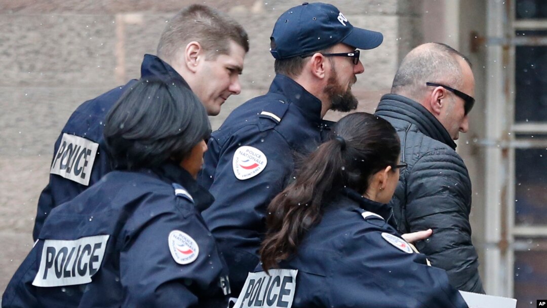 Former Kosovo prime minister Ramush Haradinaj, right, is rushed by police officers inside the Colmar courthouse in France, Jan.5, 2017. Haradinaj is facing possible extradition to Serbia to face war crimes charges after being arrested at a French airport.