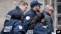 Former Kosovo prime minister Ramush Haradinaj, right, is rushed by police officers inside the Colmar courthouse in France, Jan.5, 2017. Haradinaj is facing possible extradition to Serbia to face war crimes charges after being arrested at a French airport.