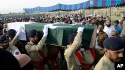 Tentara Pakistan membawa peti jenazah kandidta Siraj Raisani yang ditutupi bendera nasional, yang tewas pada bom bunuh diri hari Jumat (13/7) di Mastung, Pakistan.