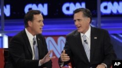 Republican presidential candidates, former Massachusetts Gov. Mitt Romney, right, and former Pennsylvania Sen. Rick Santorum argue a point during a Republican presidential debate, Mesa, Arizona, February 22, 2012.