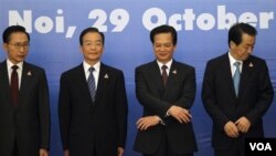 PM Vietnam Nguyen Tan Dung berusaha menggandeng tangan PM Jepang Naoto Kan (paling kanan) dan PM Wen Jiabao, sementara Presiden Korsel Lee Myung-bak (paling kiri) memperhatikan pada KTT ASEAN di Hanoi, Vietnam Jumat, 29 Oktober 2010.