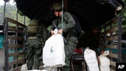 FILE - A counter narcotics police officer loads bags containing cocaine seized in Chinacota, near Colombia's northeastern border with Venezuela, March 2, 2016. 