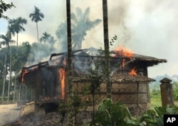 FILE - Flames engulf a house in Gawdu Zara village, northern Rakhine state, Myanmar, Sept. 7, 2017.