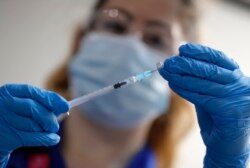 Seorang perawat menyiapkan suntikan vaksin Pfizer-BioNTech COVID-19 di Guy's Hospital di London, Selasa, 8 Desember 2020. (Foto: AP)