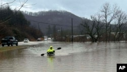 In this photo provided by Donnie Smith, a kayaker navigates floodwaters, Feb. 15, 2025, in rural Knox County, Kentucky. 