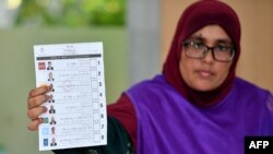 Mfanyikazi wa tume ya uchaguzi akionyesha karatasi ya kura wakati wa kuhesabu kura wakati wa uchaguzi wa rais wa Maldives Septemba 9, 2023. AFP.
