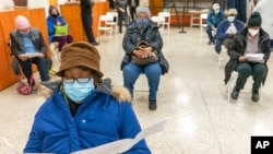 Elaine Chambers goes over a coronavirus vaccination pamphlet while resting after receiving the first dose of the vaccine at a pop-up COVID-19 vaccination site at St. Luke's Episcopal church, in the Bronx borough of New York, Jan. 26, 2021.