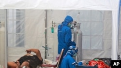 Para petugas medis merawat pasien di dalam tenda darurat yang didirikan untuk mengatasi kenaikan kasus COVID-19 di RSUP Dr. Sardjito, Yogyakarta, Minggu, 4 Juli 2021.
