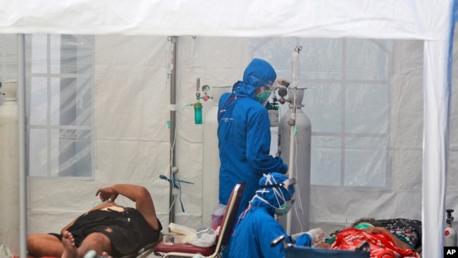 Para petugas medis merawat pasien di dalam tenda darurat yang didirikan untuk mengatasi kenaikan kasus COVID-19 di RSUP Dr. Sardjito, Yogyakarta, Minggu, 4 Juli 2021. 