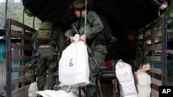 FILE - A counter narcotics police officer loads bags containing cocaine seized in Chinacota, near Colombia's northeastern border with Venezuela, March 2, 2016. 