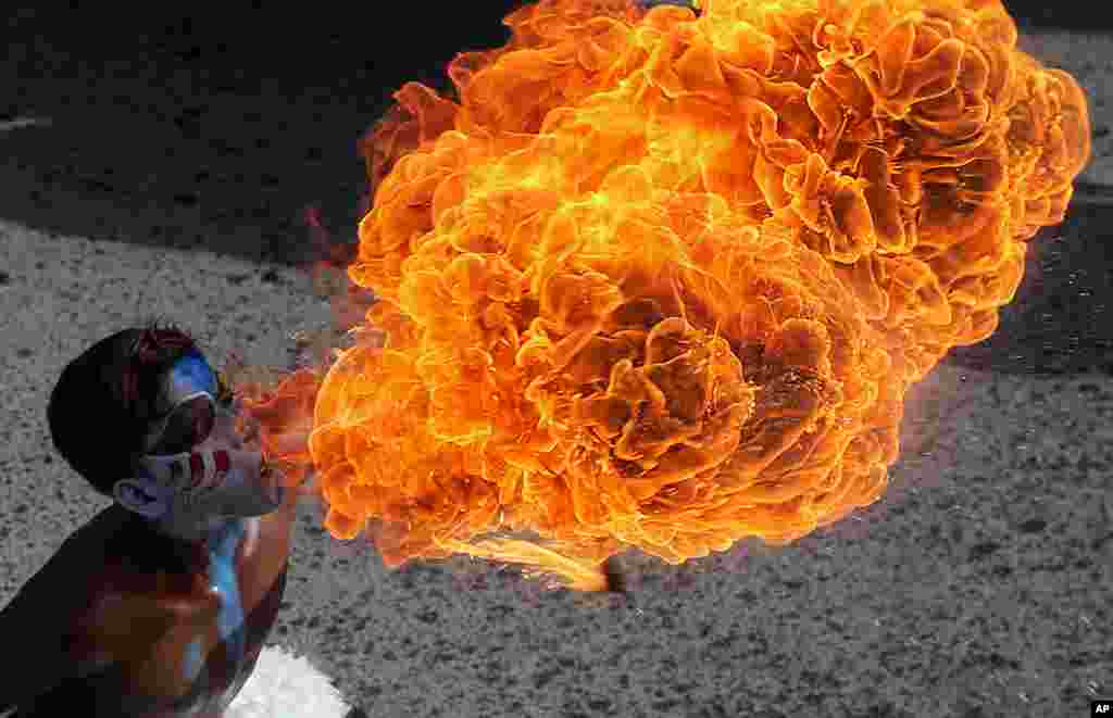 An Indian artist performs a fire act during a procession as part of &quot;Bonalu&quot; festival in Hyderabad, India.