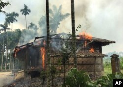 FILE - Flames engulf a house in Gawdu Zara village, northern Rakhine state, Myanmar, Sept. 7, 2017. Security forces and allied mobs burned down thousands of homes in the area, where the vast majority of the country's 1.1 million Rohingya had lived.