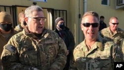 File - Chairman of the U.S. Joint Chiefs of Staff Gen. Mark Milley, left, talks with Gen. Scott Miller, the commander of U.S. and coalition forces in Afghanistan, Dec. 16, 2020 at Miller’s military headquarters in Kabul, Afghanistan. 