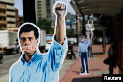Cardboard figures of jailed opposition leader Leopoldo Lopez with his mouth covered with the word 'Crime' are seen during a gathering in support of him in Caracas June 4, 2014.