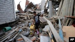 Un homme, qui a perdu sa femme enceinte, récupère quelques unes de ses affaires dans ce qu'il reste de son habitation, à La Chorrera, Equateur, le 18 avril 2016.