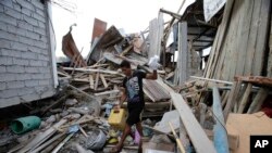 A man, whose wife and unborn son were killed during a 7.8-magnitude earthquake, recovers belongings from his collapsed home, in La Chorrera, Ecuador, April 18, 2016.