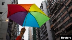 A participant holds a rainbow umbrella as he attends a lesbian, gay, bisexual and transgender (LGBT) Pride Parade in Hong Kong, Nov. 8, 2014.