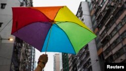 A participant holds a rainbow umbrella as he attends a lesbian, gay, bisexual and transgender (LGBT) Pride Parade in Hong Kong, Nov. 8, 2014. Participants from the LGBT communities took to the streets to demonstrate for their rights.
