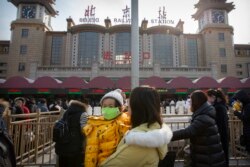 2020年1月21日北京站外抱着戴口罩孩子的一名妇女