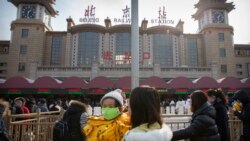 Las autoridades chinas no dan abasto a la demanda de máscaras para protegerse del nuevo brote de un coronavirus en la ciudad de Wuhan. Esta foto muestra a una madre con su hija en Beijing.