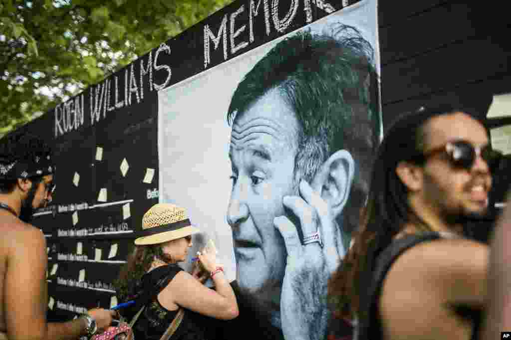 Festival goers pay tribute to the late actor Robin Williams at a makeshift memorial at the 22nd Sziget (Island) Festival on the Shipyard Island in northern Budapest, Hungary, Aug. 13, 2014. 