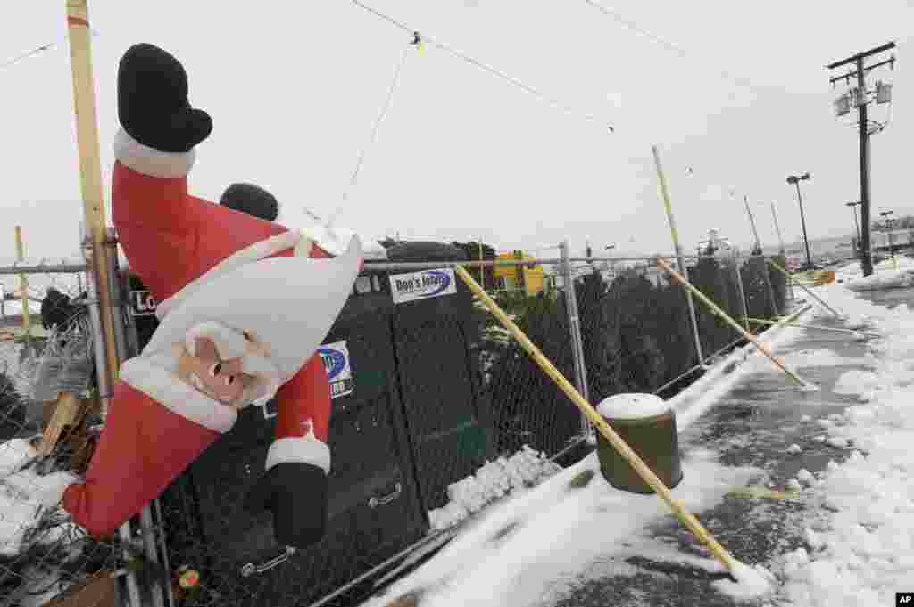 An inflatable Santa hangs upside down at a Christmas tree stand in Timonium, Maryland, Dec. 9, 2013.