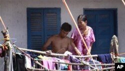 A Cambodian couple dry clothes at their home in flood. 