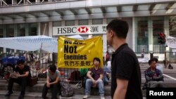 Para demonstran beristirahat di depan sebuah cantor cabang bank HSBC yang ditutup semenjak jalanan terblokir demo di kawasan perbelanjaan Mongkok, Hong Kong (7/10).