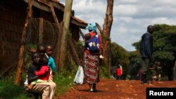 FILE - A mother carries her baby on her back in Kenya.