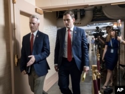 Rep. Steve Russell, R-Okla., left, and Rep. Mike Gallagher, R-Wis., walk to a closed-door meeting with House Republicans seeking more information about compromise legislation on immigration, at the Capitol in Washington, June 21, 2018.