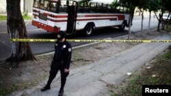 A policeman secures a crime scene after a bus driver was killed by suspected gang members during a suspension of public transport services in San Salvador, July 27, 2015.