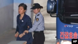 Former South Korean President Park Geun-hye, left, arrives for her trial at the Seoul Central District Court in Seoul, South Korea, Oct. 16, 2017. 