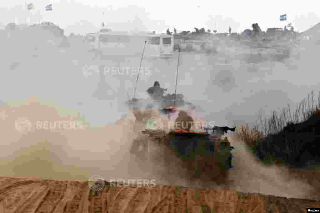 Israeli soldiers travel in armored personnel carriers, near the Gaza Strip, July 15, 2014.
