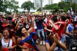 Los fanáticos panameños celebran el gol de su equipo mientras ven una transmisión en vivo del partido de fútbol del Grupo G del Mundial entre Túnez y Panamá, en la ciudad de Panamá, el jueves 28 de junio de 2018. Túnez ganó el partido por 2-1. (AP Photo / Arnulfo Franco)