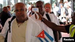 Un trabajador de salud toma la temperatura a un médico al arribar a un aeropuerto de África. 