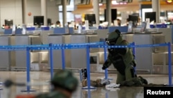 A bomb disposal expert checks a luggage near the site of a blast at a terminal in Shanghai's Pudong International Airport, China, June 12, 2016.