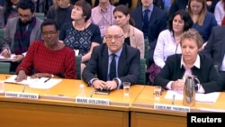 Oxfam's chief executive Mark Goldring, center, Oxfam's international director Winnie Byanyima (left) and Oxfam's chair Caroline Thomson attend a hearing of the British parliament's International Development Committee in London, Britain, Feb. 20, 2018. 