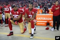 미 프로미식축구, 샌프란시스코 포티나이너스의 쿼터백 콜린 캐퍼닉(오른쪽)이 지난해 9월 열린 경기 국민의례에서 동료와 함께 무릎을 꿇고 인종 차별에 항의하고 있다.