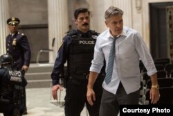 George Clooney as Lee Gates, right, stars with Giancarlo Esposito as Captain Marcus Powell, left, and Anthony DeSando as Officer Benson, center, in TriStar Pictures' “Money Monster.”