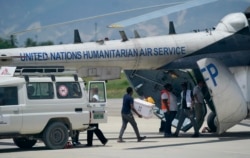 People load emergency supplies from a Doctors Without Borders ambulance into a United Nations helicopter bound for the earthquake ravaged city Les Cayes, at the local terminal of the Toussaint Louverture airport in Port-au-Prince, Haiti, Sunday, Aug. 15,