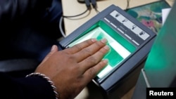 In this file photo, a woman goes through the process of finger scanning for the unique identification database system, also known as Aadhaar, at a registration center in New Delhi, India, Jan. 17, 2018.