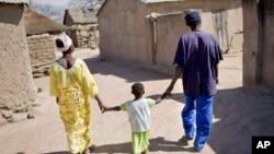 Health worker (right) walks with a mother and her child in Satiguila, Mali.